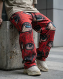 Ocular Crimson Wide Leg Trousers featuring detailed eye graphics on a crimson backdrop.