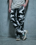Person wearing Noir Visage Wide Leg Trousers by CLAZZEY with a monochromatic graphic of airbrushed eyes.