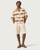 Compass Boxy-Fit Cuban Shirt buttoned with cream pleated shorts
