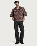 Masquerade Boxy-Fit Cuban Shirt buttoned with black jeans and loafers