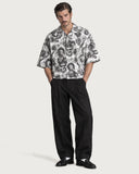Tattoo Boxy-Fit Cuban Shirt buttoned with black pleated trousers and loafers